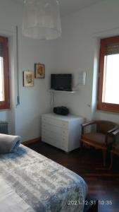 een slaapkamer met een bed, een tv en een stoel bij Casa Vacanze LELUPE in Sant'Agnello