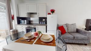 eine Küche und ein Wohnzimmer mit einem Tisch und einem Sofa in der Unterkunft Symons House in Chatham
