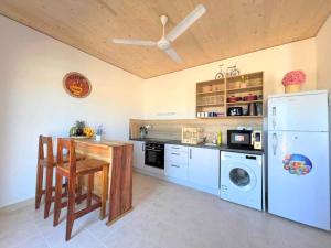 a kitchen with a table and a refrigerator at Homerent @ Fumba-Town in Dambani