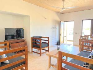 a living room with a tv and wooden furniture at Homerent @ Fumba-Town in Dambani