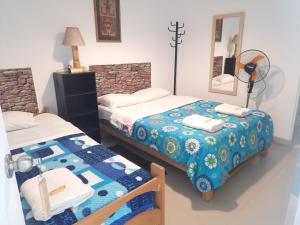 a bedroom with two beds and a mirror at Hostal Brisa Marina in Paracas