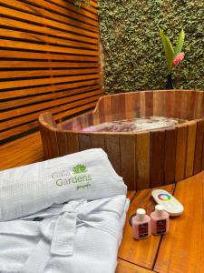 uma mesa de madeira com uma toalha e uma banheira em Gaia Gardens Pousada em Paraty