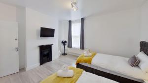 a white room with two beds and a fireplace at Kings House in Gillingham