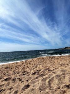 plaża ze śladami stóp na piasku i oceanem w obiekcie Maison accueillante avec vue sur la mer à Grosseto-Prugna w mieście Grosseto-Prugna +8 zdjęć