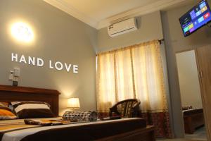 a bedroom with a bed and a sign that reads hand love at HAND LOVE in Cotonou