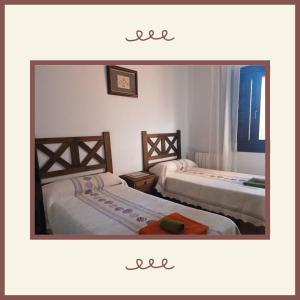two beds in a room with a mirror at Casa rural Bohilgues in Vallanca