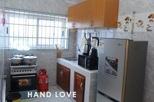a kitchen with a refrigerator freezer next to a stove at HAND LOVE in Cotonou