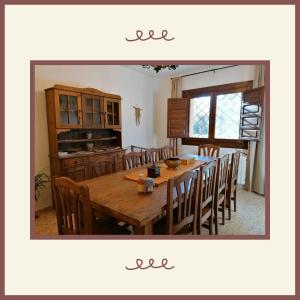 uma sala de jantar com uma mesa de madeira e cadeiras em Casa rural Bohilgues em Vallanca