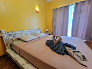 a bedroom with a bed with a heart towel on it at Villa ARC-EN-CIEL in Petite Île