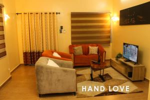 a living room with a couch and a tv at HAND LOVE in Cotonou