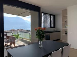 eine Küche mit einem Tisch und einer Blumenvase darauf in der Unterkunft SKY in Lugano