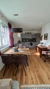 Ferienwohnung Karasek Deluxe في Sattendorf: غرفة معيشة مع طاولة خشبية وغرفة طعام