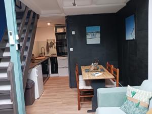 une salle à manger avec une table et une cuisine dans l'établissement Cocoon'House, à Gruissan