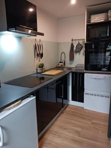 a kitchen with black cabinets and a counter top at Cocoon'House in Gruissan +20 photos