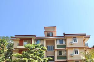 a tall building with trees in front of it at Kay's Calangute Resort Service Apartments in Calangute