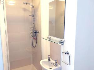 W łazience znajduje się umywalka oraz prysznic z lustrem. w obiekcie Fab 3-bed 3-bath Duplex Oxford Street, Regents Park, Fitzrovia W1 w Londynie
