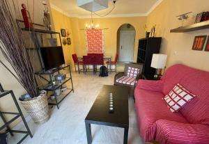 a living room with a red couch and a table at E2 equipado en Playa Granada con terraza de 11m2 in Motril