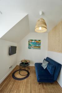 salon z niebieską kanapą i stołem w obiekcie Le perchoir *hyper centre * A 2 pas de la mer * w mieście Concarneau