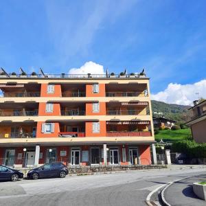 un edificio naranja con pájaros sentados encima de él en Appartamento Pizzo di Parlasco - Your Mountain Holiday, en Taceno