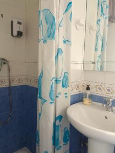 baño con lavabo y cortina de ducha en Casa Kalma en Cazorla