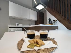 un vassoio con due bevande e biscotti sul bancone della cucina di Chez Emma et Louise - Maison individuelle avec stationnement gratuit a Mâcon Altre 8 foto