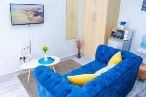 a blue couch in a living room with a table at LaMeg Furnished Studio in Fedha in Nairobi