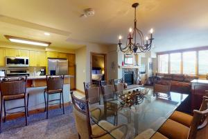 een eetkamer en een keuken met een glazen tafel en stoelen bij Torian Creekside III in Steamboat Springs