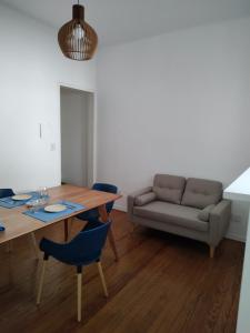 uma sala de estar com uma mesa e um sofá em Caminito Apart em Buenos Aires
