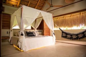 a bedroom with a bed with a mosquito net at Nativa Refugio Escondido in Santa Fe de Antioquia