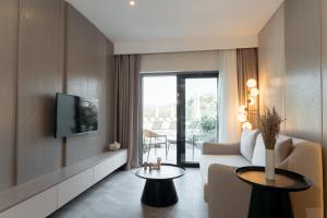 ein Wohnzimmer mit einem Sofa und einem TV in der Unterkunft Bodrum Astrid Hotel in Gümüşlük