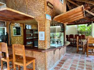 a restaurant with a counter with wooden chairs and tables at Wind Rider's Inn in Boracay