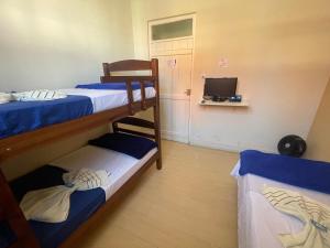 a room with two bunk beds and a television at Pousada Casa de Bragança II in Bragança Paulista