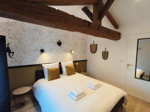 a bedroom with a large white bed with two pillows at Chez Emma et Louise - Maison individuelle avec stationnement in Mâcon