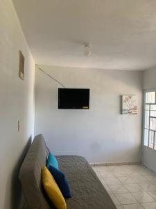 a living room with a couch and a flat screen tv at CRAB ISLAND ADVENTURES APARTMENTS in Vieques