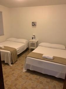 Habitación con 2 camas y mesa con lámpara. en CRAB ISLAND ADVENTURES APARTMENTS en Vieques