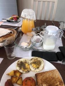 a table with a plate of food with eggs and bread at LEHAE BNB in Mbabat