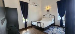 Kamalia Villas في كامبونج بيناريك: غرفة نوم بسرير مع ستائر زرقاء ومرآة