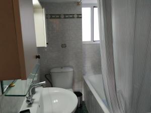 uma casa de banho com um WC, um lavatório e um chuveiro em Central Kiato em Kiato