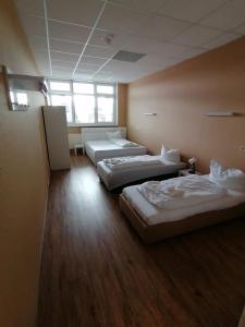 three beds in a room with wooden floors at 3 Bett Zimmer in Ramstein-Miesenbach