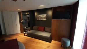 a living room with a couch and a flat screen tv at Appartement Wettersteinblick mit Sauna und Pool in Seefeld in Tirol