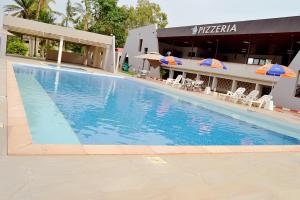 a large swimming pool in front of a hotel at Hôtel Printemps Mont Korhogo in Korhogo