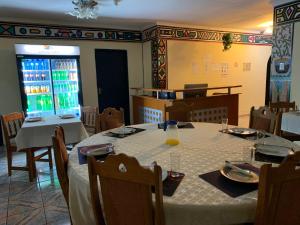 Sikhula Sonke Guest House في برونكهورستسبرويت: غرفة طعام مع طاولة مع قطعة قماش بيضاء