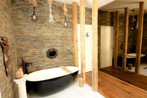a bathroom with a bath tub and a brick wall at XuBa ApartmentRooms Messe Wien Prater in Vienna
