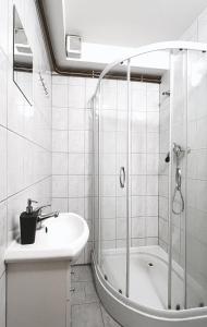 a white bathroom with a tub and a sink at Penzion Zahrádka in Lázně Bohdaneč
