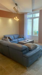 a living room with a blue couch and a table at Logis de la Foulerie in Bize-Minervois