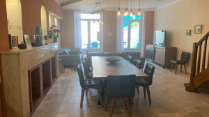 a dining room with a table and chairs and a fireplace at Logis de la Foulerie in Bize-Minervois