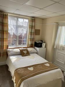 1 dormitorio con 1 cama grande y ventana en Clarendon Lodge - accommodation only, en Skegness