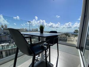 einen Tisch und Stühle auf einem Balkon mit Aussicht in der Unterkunft Caramela Luxury Apts in Ayia Napa