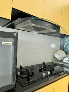 a kitchen with a stove top with a hood at Meritus Studio Holiday (Perai) in Perai