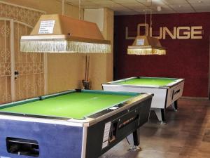duas mesas de snooker numa sala com um ping em Appartement zur Bergoase mi Schwimmbad em Hohegeiß